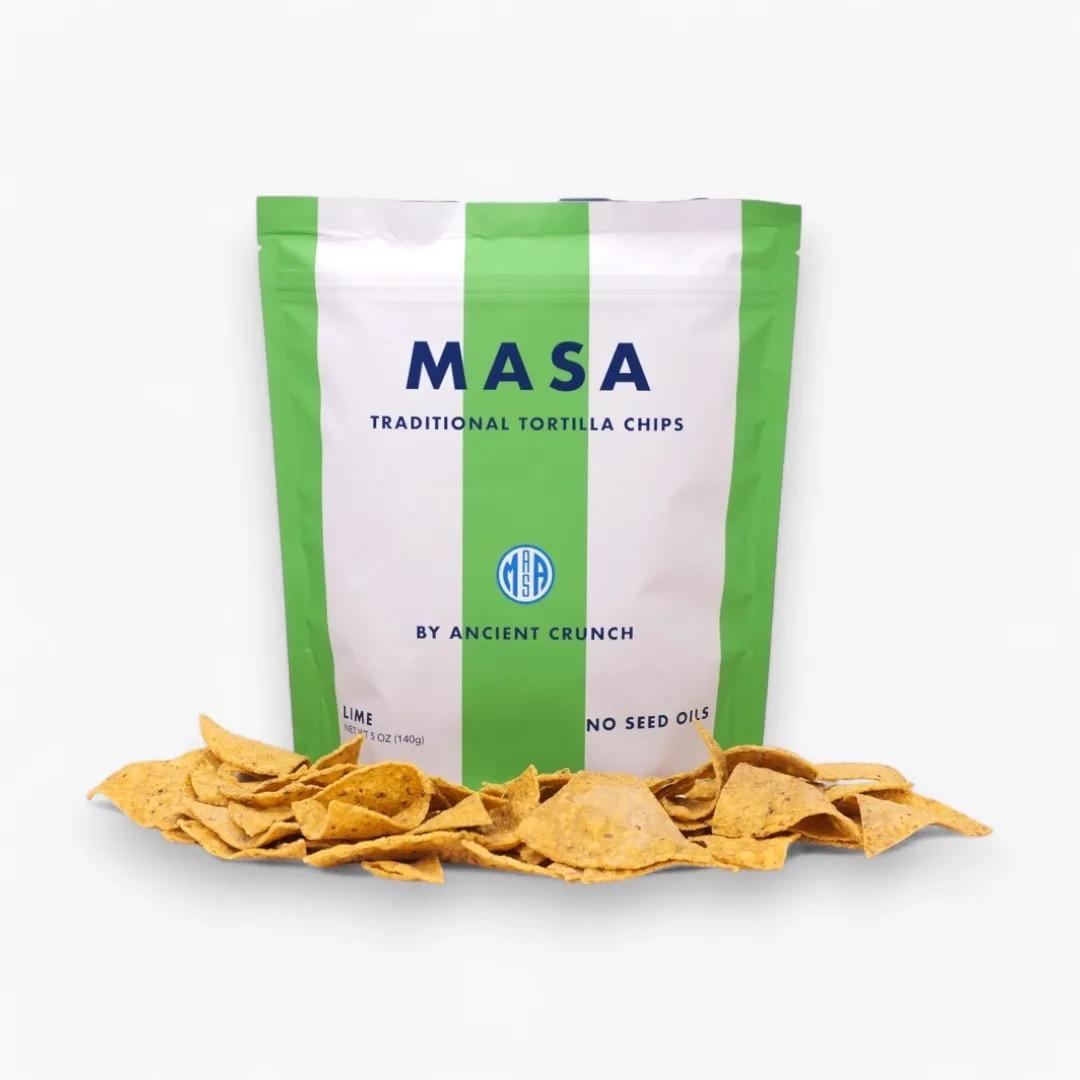 Bag of Masa Lime traditional tortilla chips with crispy stone-ground corn chips scattered in front