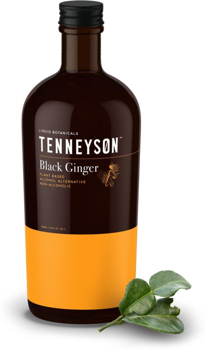 Bottle of Tenneyson Black Ginger non-alcoholic botanical spirit with a yellow label and fresh green leaves beside it