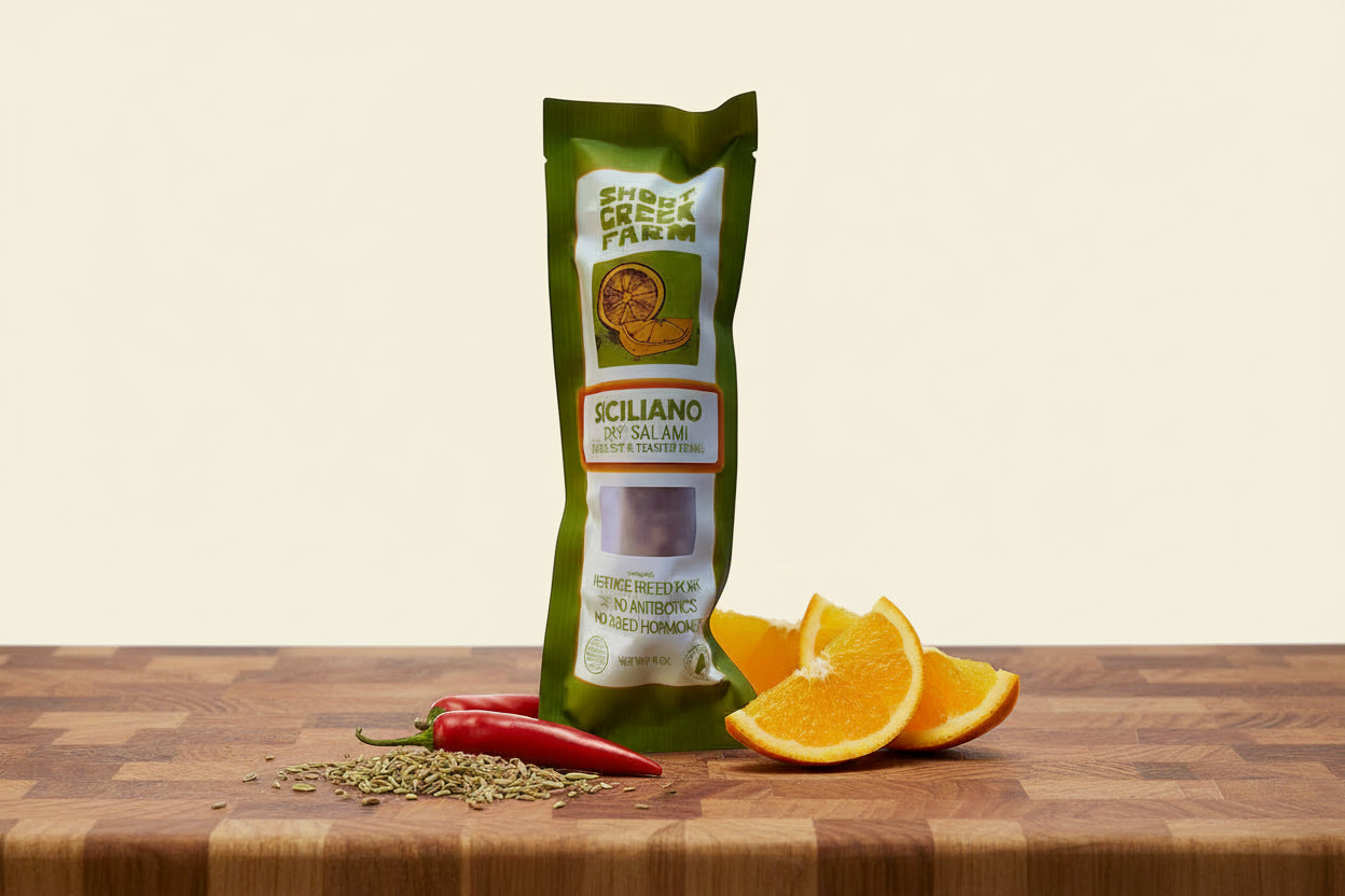 Green package of Siciliano dry salami on a white background