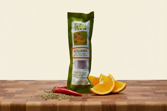 Green package of Siciliano dry salami on a white background