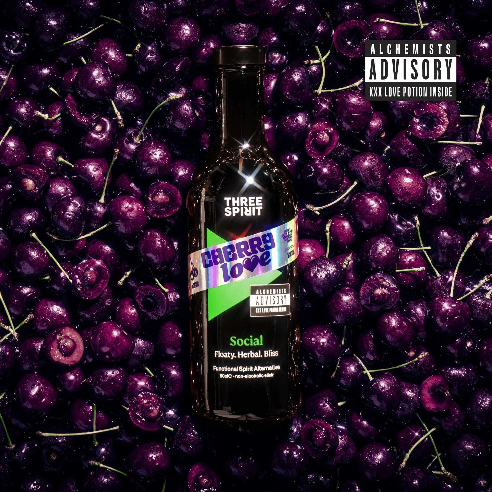 Bottle of Three Spirit Cherry Love surrounded by cherries with 'Alchemists Advisory' text.